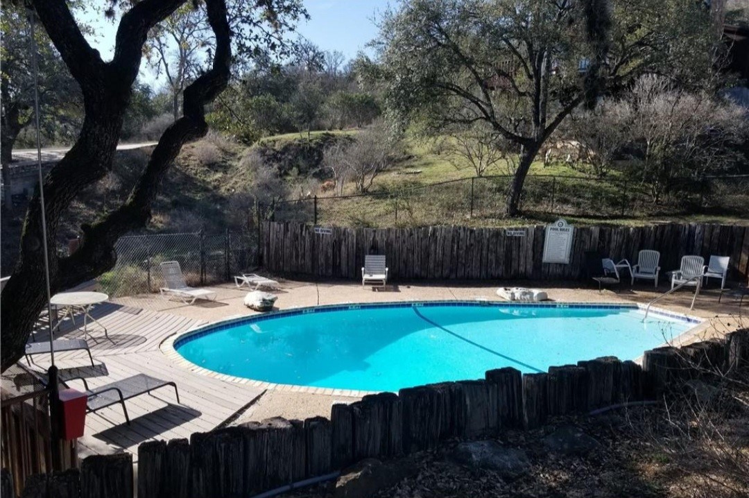 1033 Coventry Road Spicewood, TX 78669 - Photo 12 of 13 a swimming pool with outdoor seating and yard