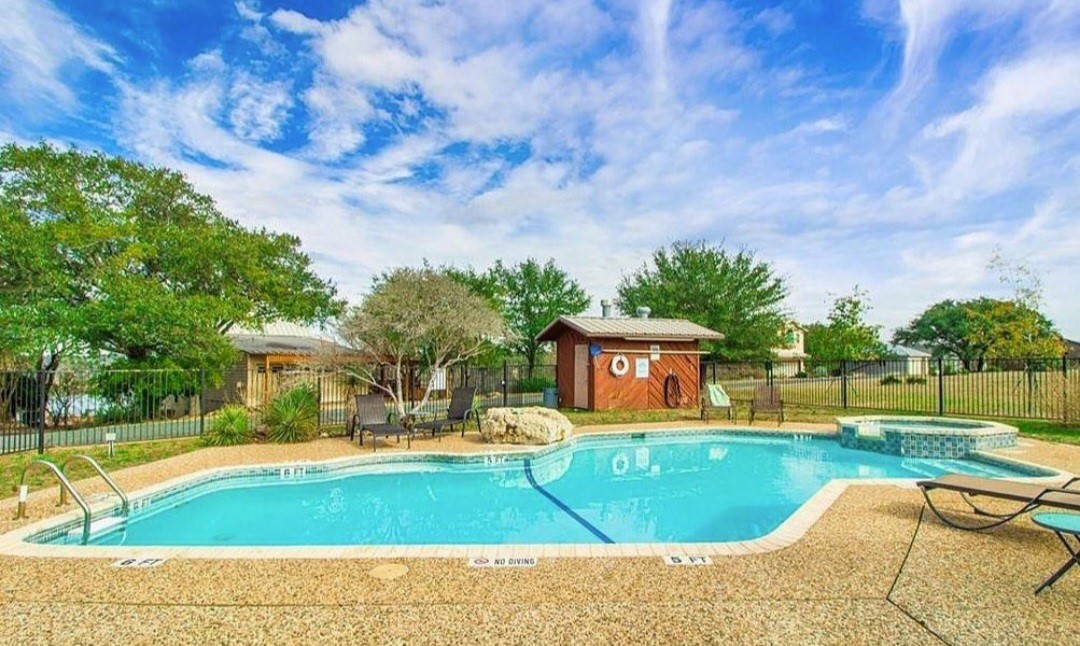1033 Coventry Road Spicewood, TX 78669 - Photo 6 of 13 a view of a swimming pool with a lounge chairs