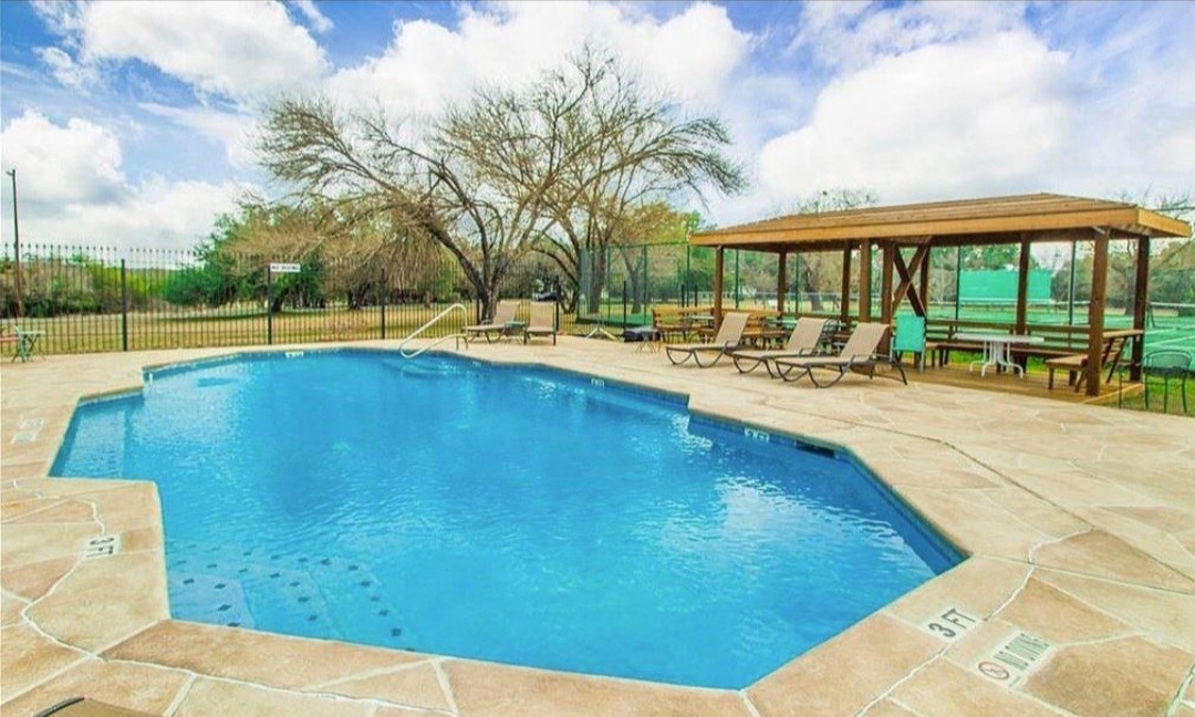 1033 Coventry Road Spicewood, TX 78669 - Photo 8 of 13 a view of swimming pool with outdoor seating and a garden