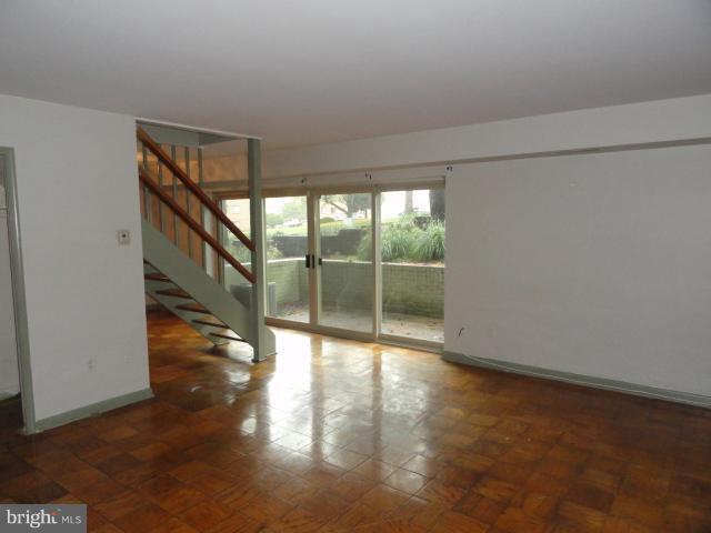 8620 Manchester Road, Unit 3 Silver Spring, MD 20901 - Photo 2 of 9 a view of an empty room with wooden floor and a window