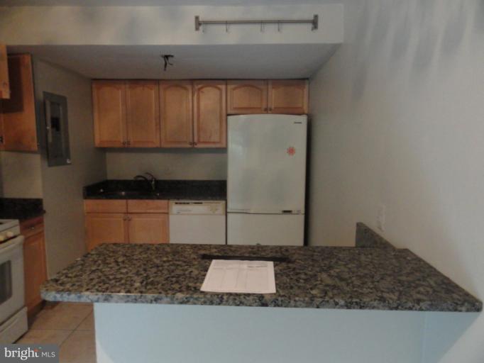 8620 Manchester Road, Unit 3 Silver Spring, MD 20901 - Photo 4 of 9 a kitchen with kitchen island granite countertop a sink and a stove