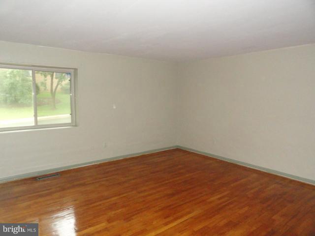 8620 Manchester Road, Unit 3 Silver Spring, MD 20901 - Photo 6 of 9 an empty room with wooden floor and windows