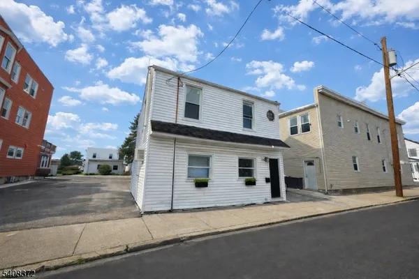 a view of a white house with a street