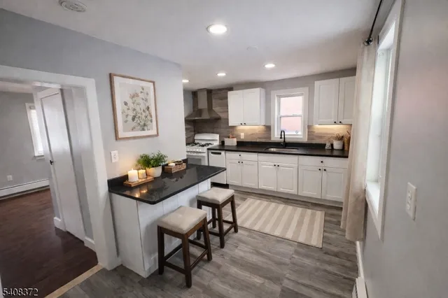 a kitchen with granite countertop a sink cabinets and wooden floor