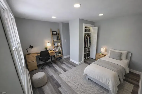 a spacious bedroom with a bed and wooden floor