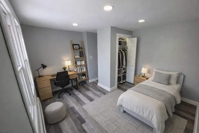 a spacious bedroom with a bed and wooden floor