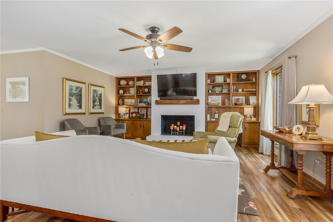 207 Laurel Ridge Road Anderson, SC 29621 - Photo 8 of 50 Built-in shelving flanks a brick fireplace, anchoring this cozy living room with warm wood flooring.