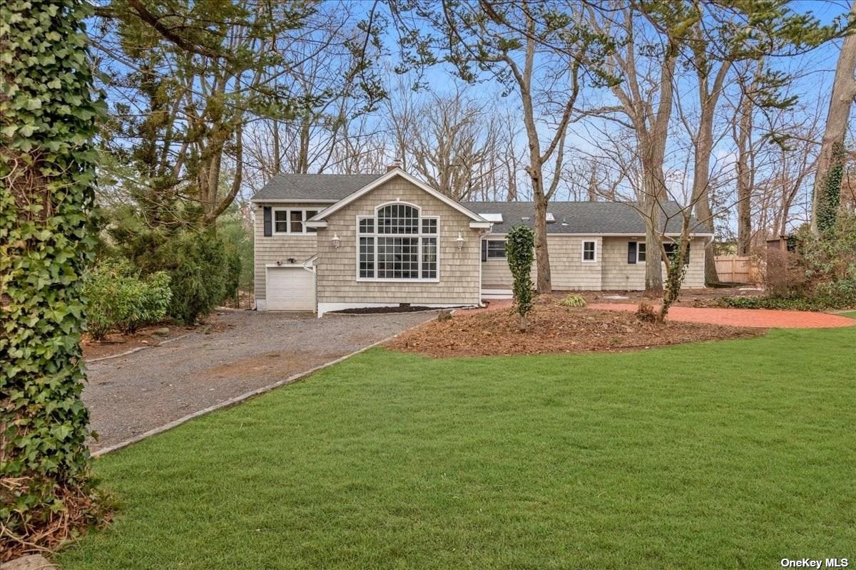 514 Main Street Cold Spring Harbor, NY 11724 - Photo 1 of 1 a front view of a house with a garden and trees
