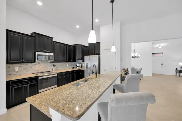 a kitchen with stainless steel appliances granite countertop a kitchen island a cabinets and a refrigerator