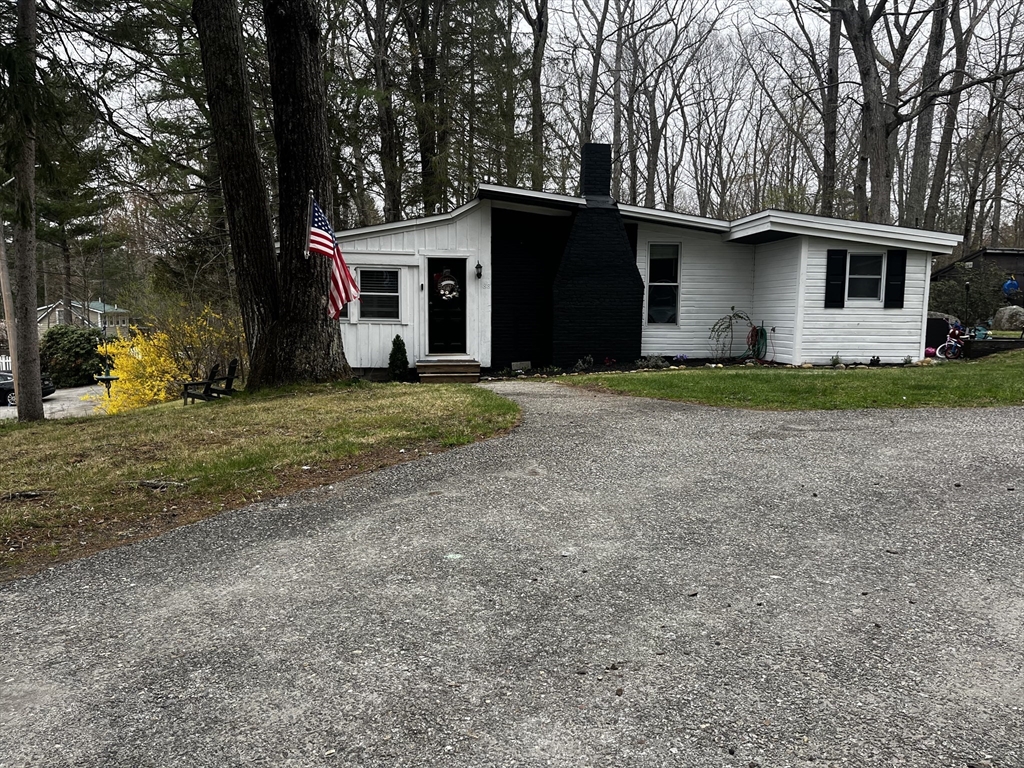 a view of a house with backyard and trees
