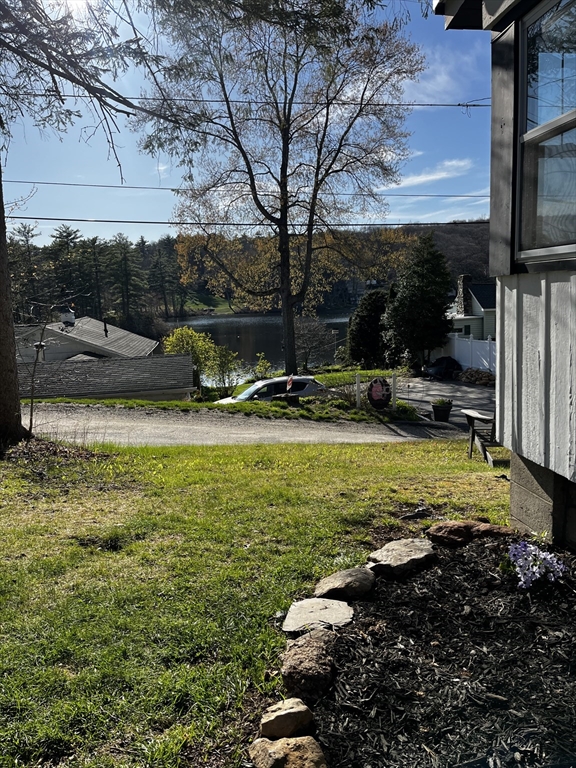 88 Hiland Road Charlton, MA 01507 - Photo 11 of 11 a view of a swimming pool with lawn chairs under an umbrella