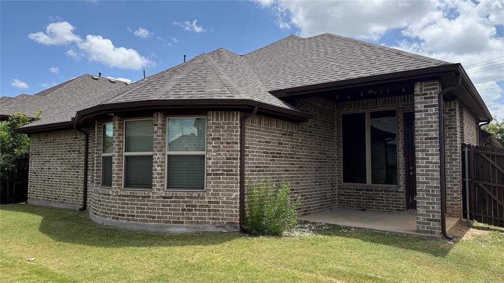 14712 Spitfire Trail Fort Worth, TX 76262 - Photo 3 of 25 Brown brick exterior featuring a covered patio, a bay window, and a shingled roof