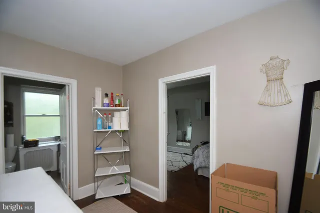 a bathroom view of a toilet and a hardwood floor