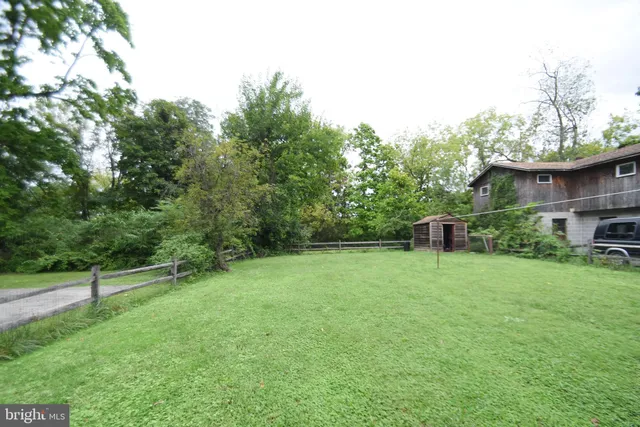a couple of cars parked in front of a white house