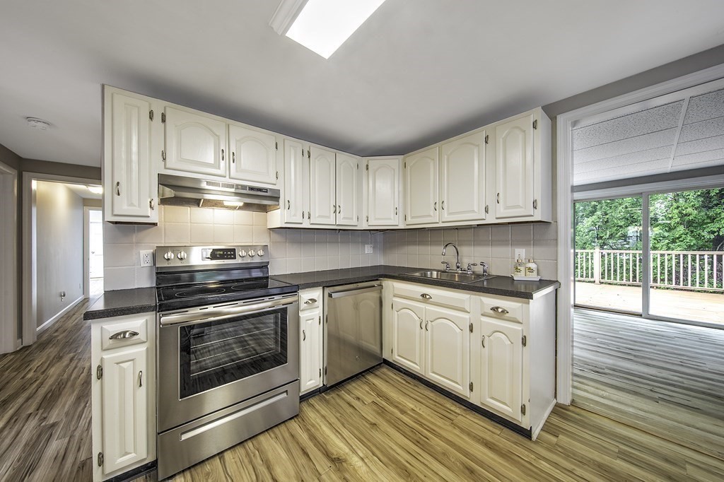 40 Brookside Avenue Danvers, MA 01923 - Photo 8 of 27 a kitchen with stainless steel appliances granite countertop a stove and white cabinets