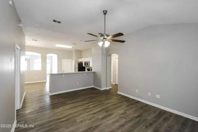 a view of a livingroom with a ceiling fan window a ceiling fan and wooden floor