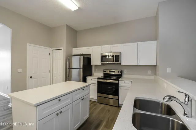 a kitchen with a sink appliances and cabinets