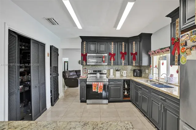 a kitchen with stainless steel appliances granite countertop a sink stove and refrigerator