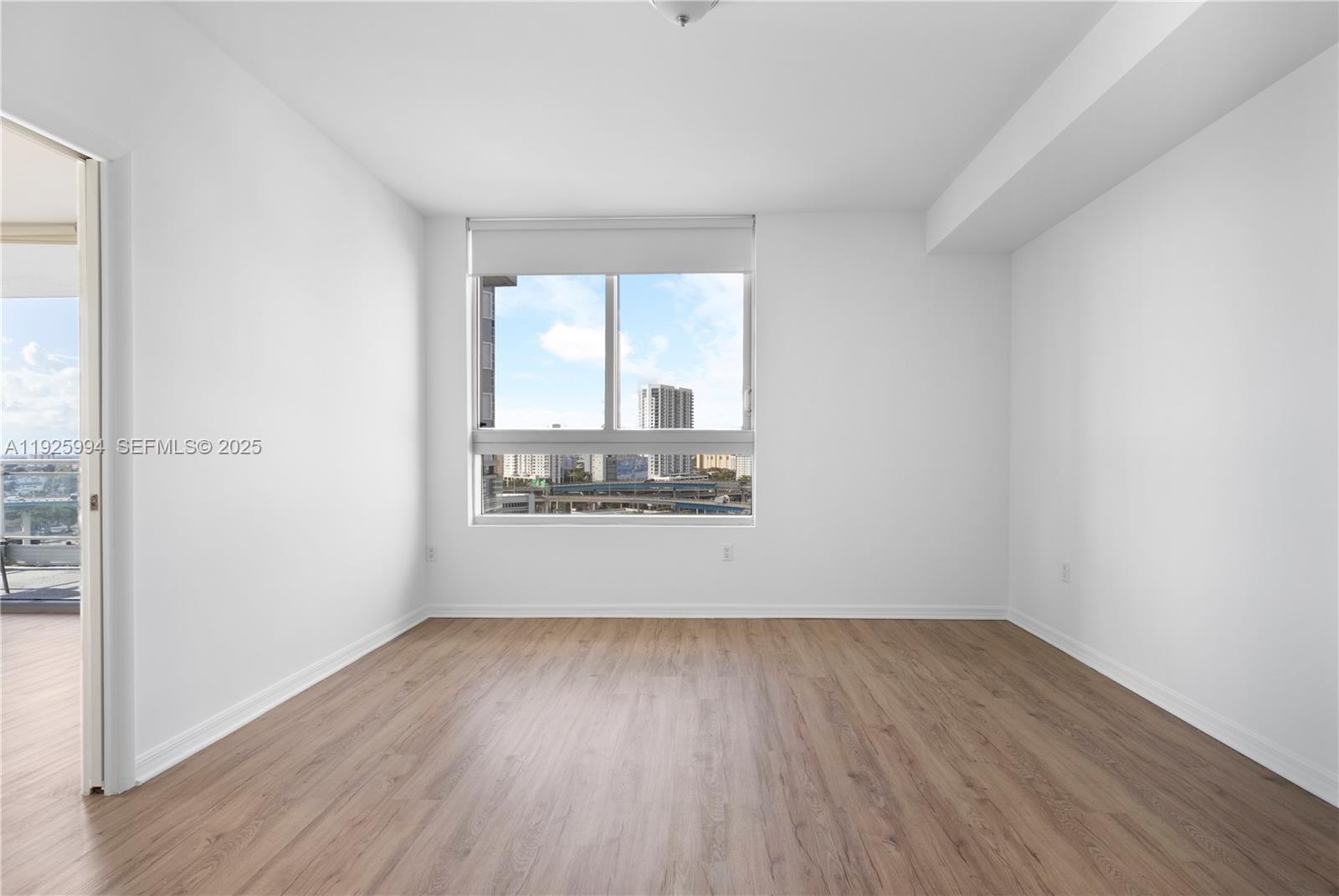 90 Southwest 3rd Street, Unit 1512 Miami, FL 33130 - Photo 13 of 19 an empty room with wooden floor and windows