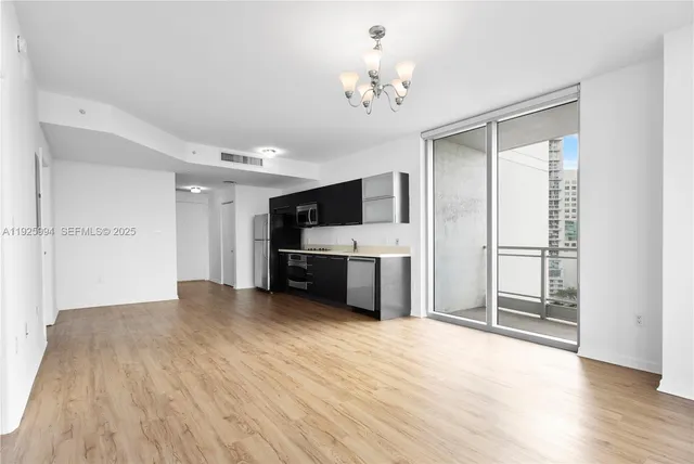 a view of a kitchen with a sink and a refrigerator