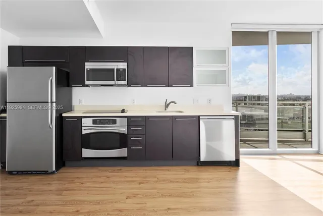 a kitchen with stainless steel appliances a stove a microwave and a refrigerator