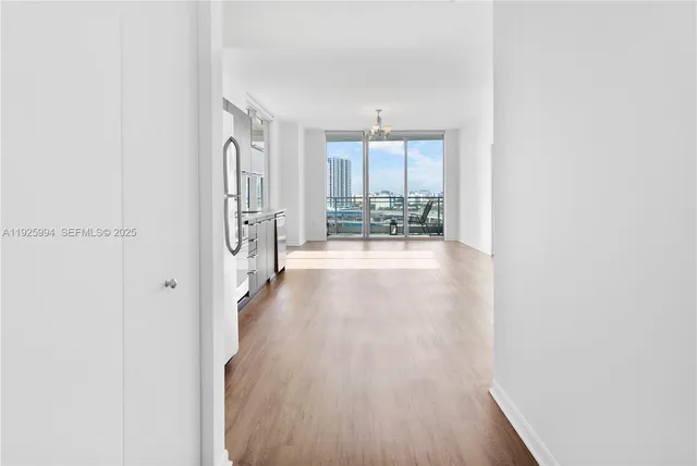 a view of a hallway with wooden floor and furniture