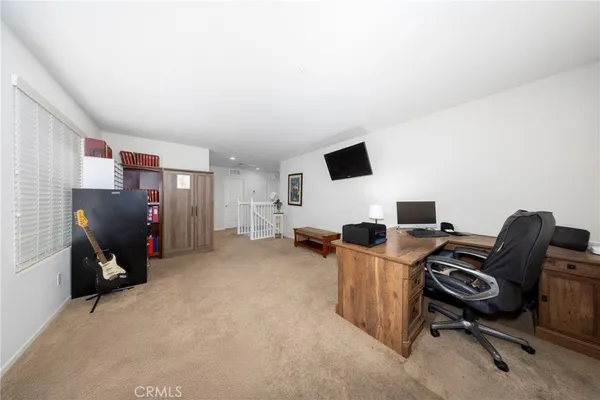 a view of a workspace with furniture and a window
