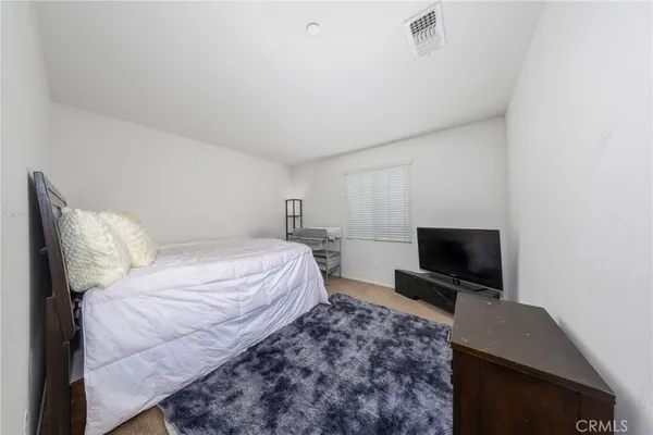 a bedroom with a bed and a television