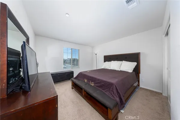 a bedroom with a bed window and a flat screen television