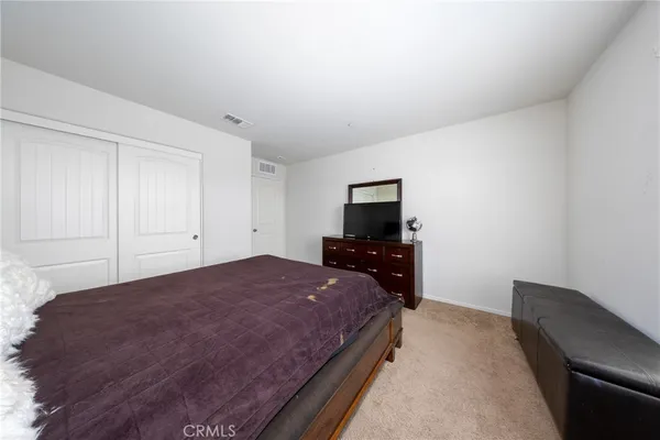 a spacious bedroom with a bed and a tv