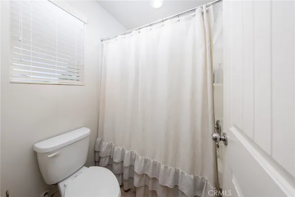a white toilet sitting next to a shower curtain
