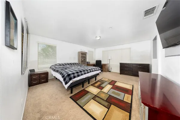 a bedroom with a bed and flat screen tv