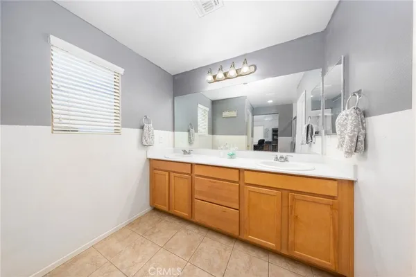 a spacious bathroom with a double vanity sink and a mirror