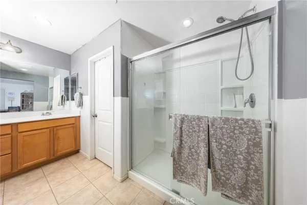 a bathroom with a granite countertop sink a mirror a vanity and shower