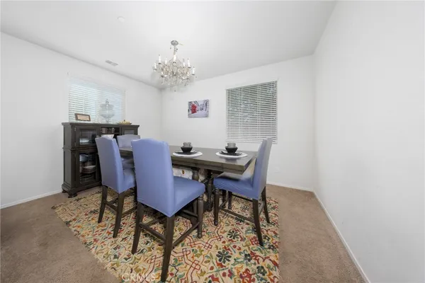 a view of a dining room with furniture and a chandelier