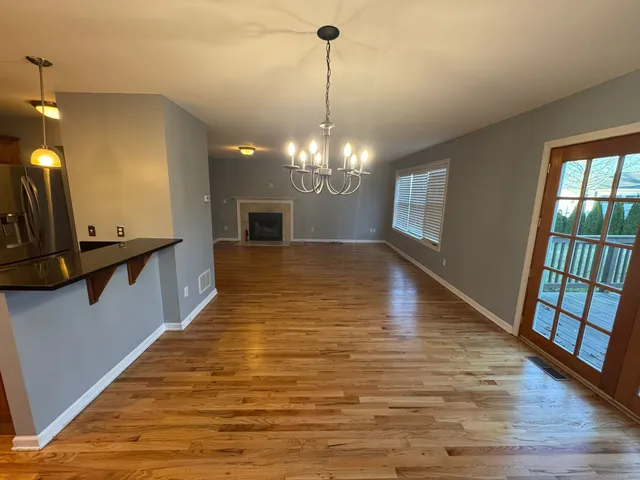 a view of a hallway with furniture and a chandelier