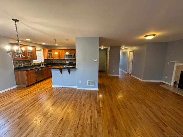 a view of a kitchen with wooden floor and a sink