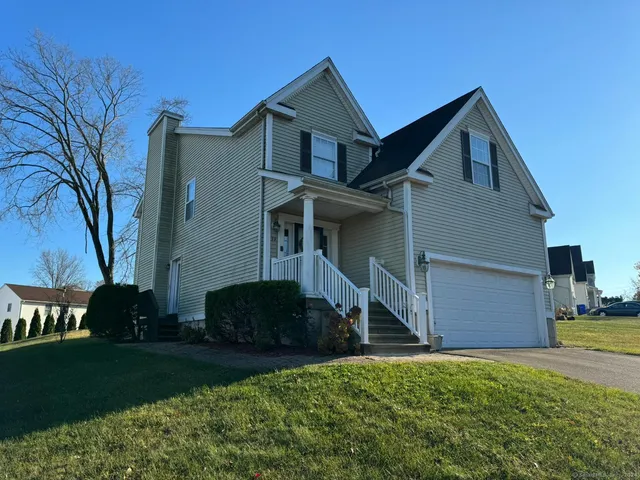 a front view of a house with a yard and a garage