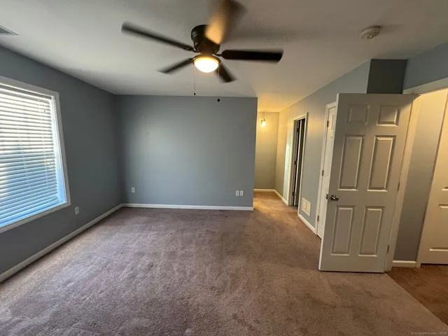 an empty room with a window and a ceiling fan
