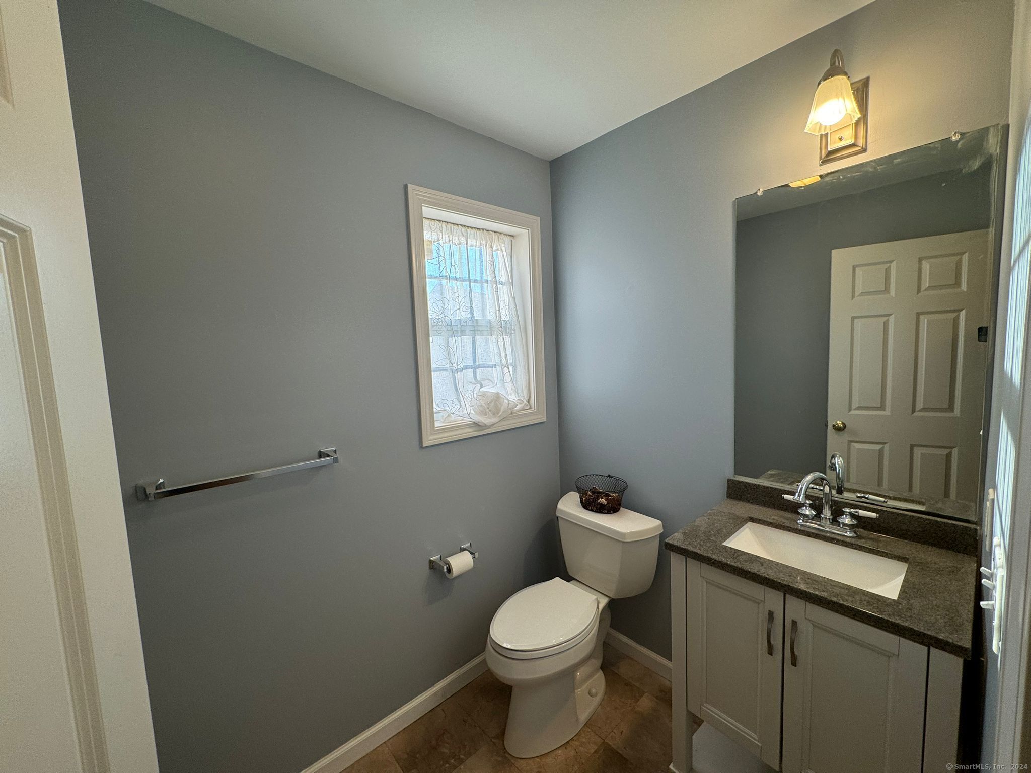 59 Gilbert Lane Branford, CT 06405 - Photo 30 of 40 a bathroom with a granite countertop toilet a sink and mirror