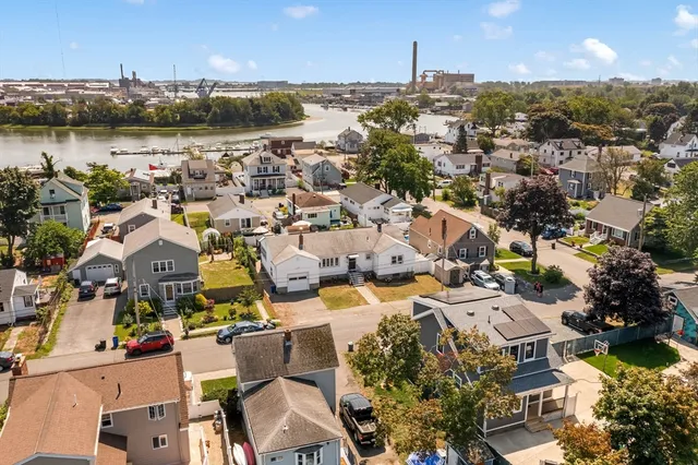 an aerial view of a city with lots of residential buildings ocean and boats