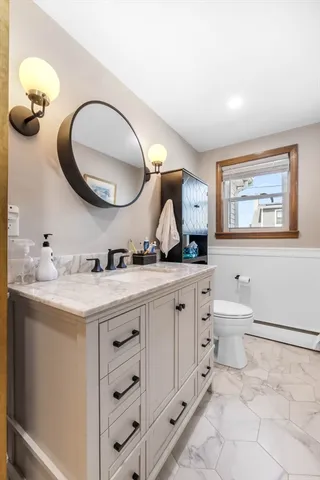 a spacious bathroom with a granite countertop toilet a sink and a mirror