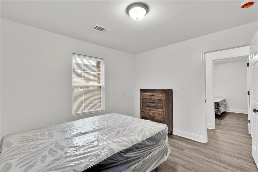 614 Elberta Street Fort Valley, GA 31030 - Photo 12 of 31 a bedroom with a bed and wooden floor