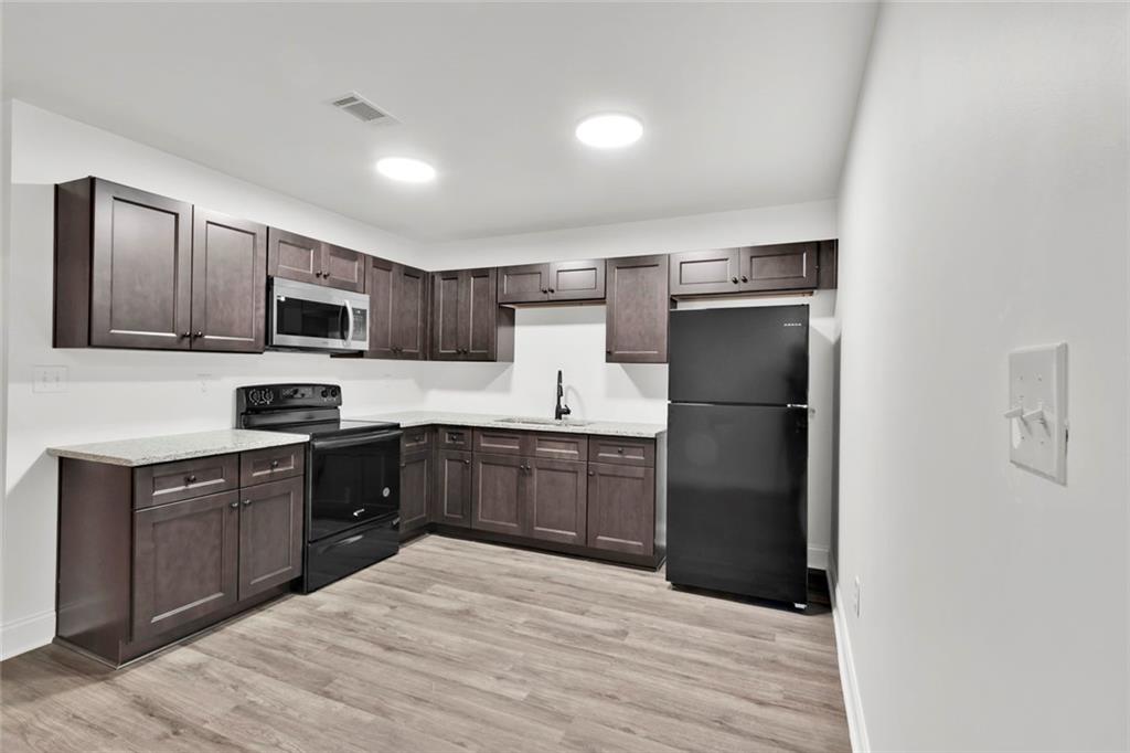 614 Elberta Street Fort Valley, GA 31030 - Photo 19 of 31 a kitchen with a refrigerator stove microwave and sink