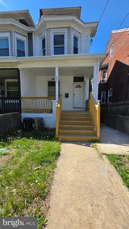a view of a house with a small yard and wooden fence
