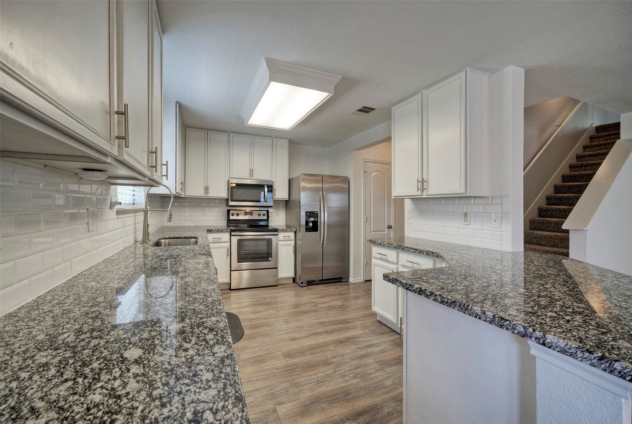 140 Plum Path Kyle, TX 78640 - Photo 5 of 22 a kitchen with stainless steel appliances granite countertop a sink refrigerator and cabinets