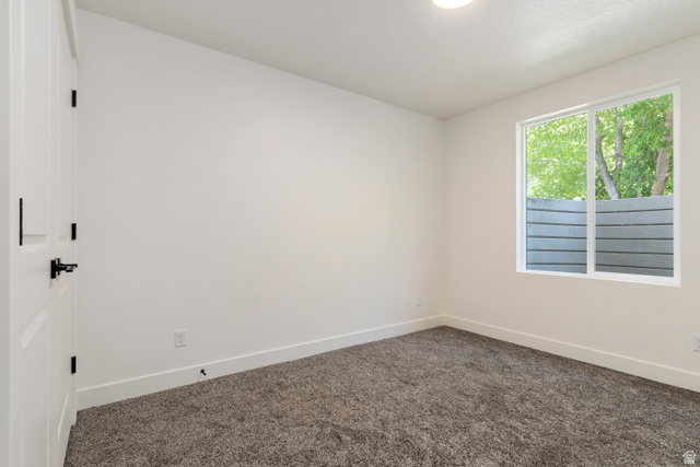 504 North 650 E Street Springville, UT 84663 - Photo 32 of 36 Spacious room featuring neutral paint, gray carpet, a white framed window, and a white door with matte black hardware