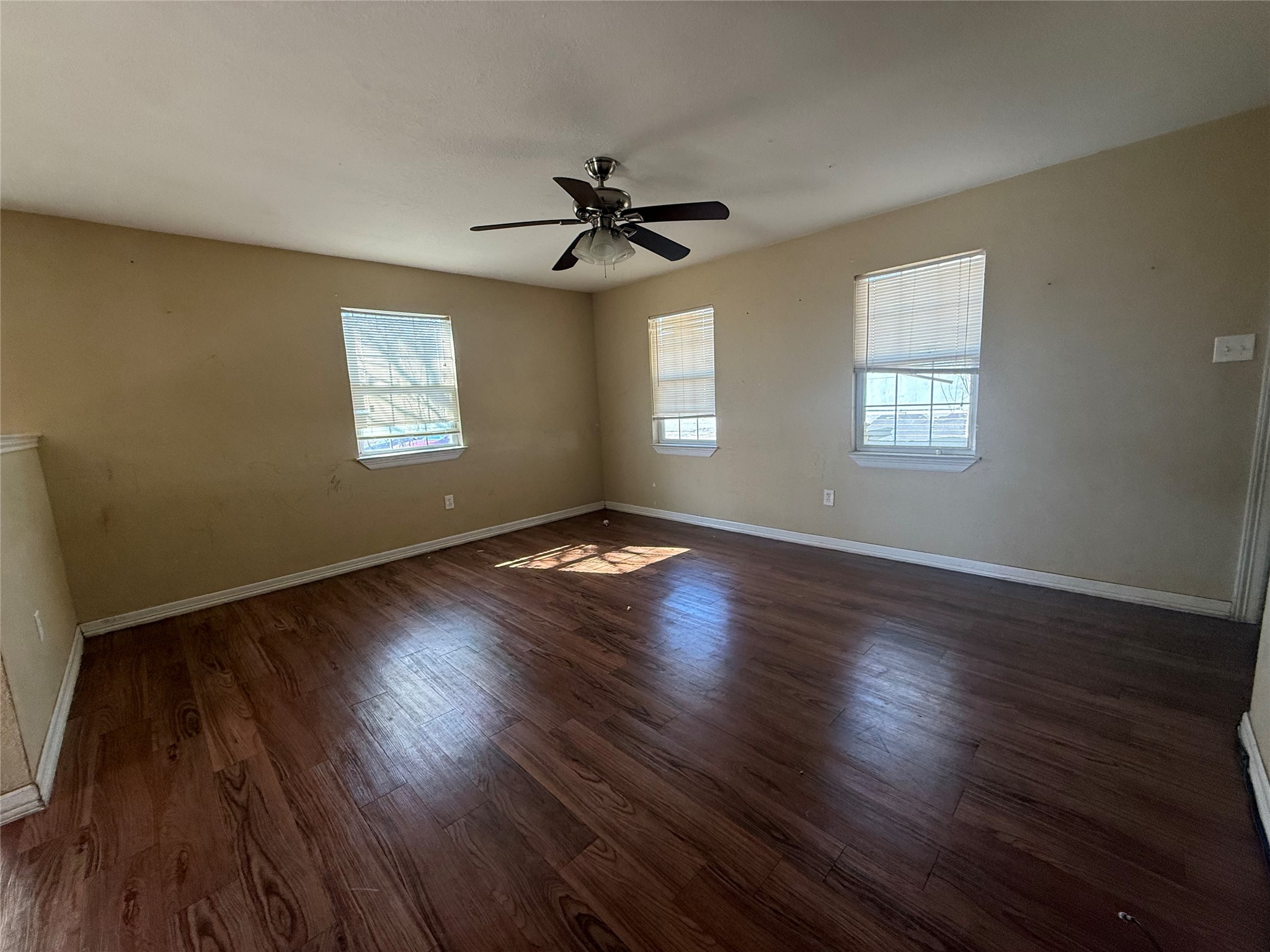 15501 Connie Street Austin, TX 78728 - Photo 9 of 26 Empty room with dark wood finished floors, healthy amount of natural light, and ceiling fan