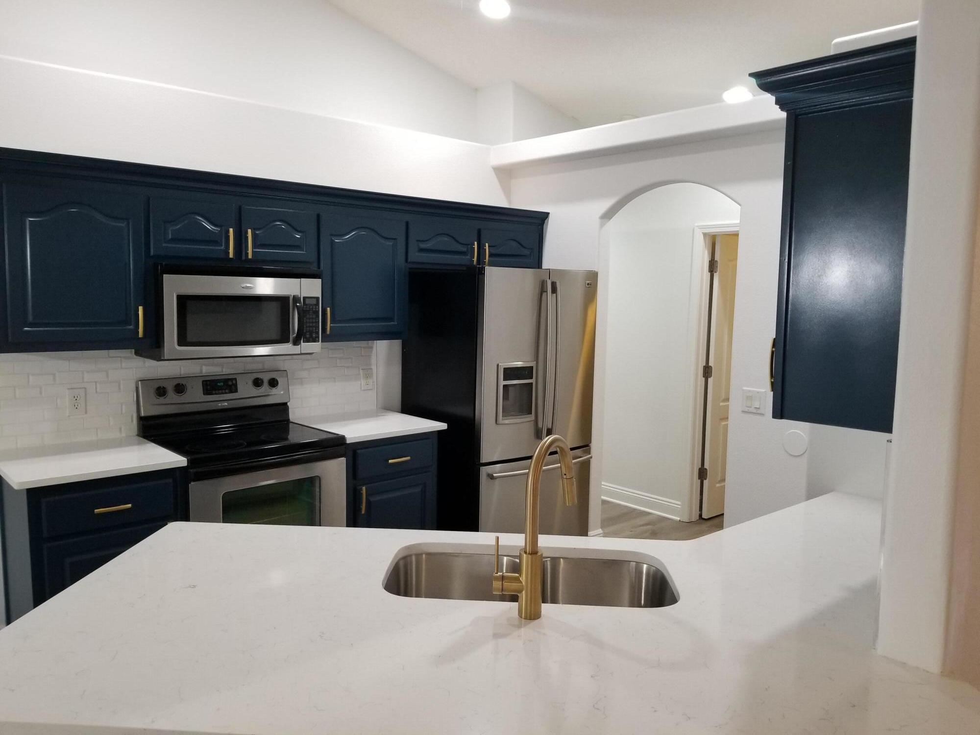 6673 Redfield Street Navarre, FL 32566 - Photo 11 of 32 a kitchen with granite countertop a refrigerator and a sink