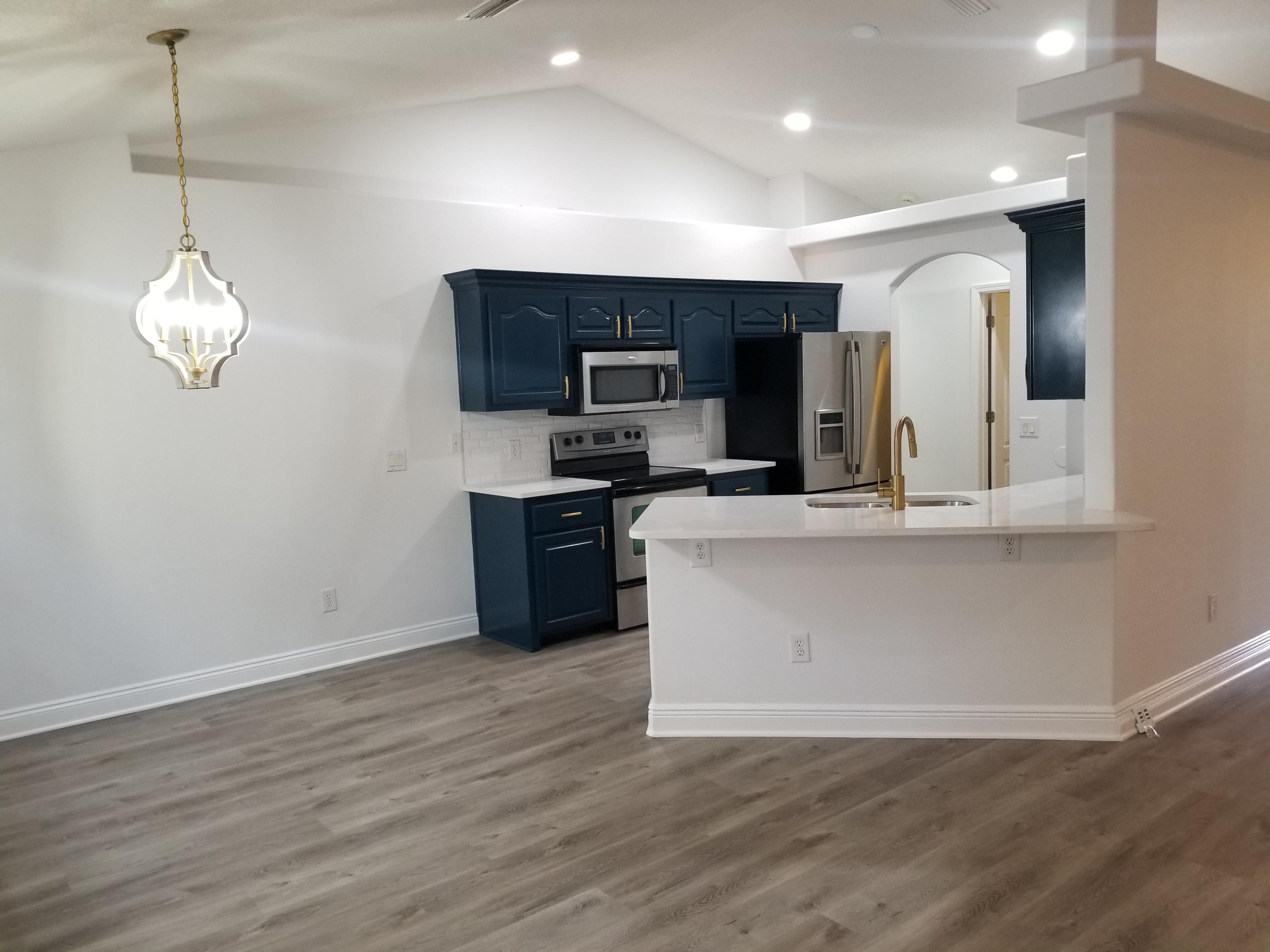 6673 Redfield Street Navarre, FL 32566 - Photo 15 of 32 a large kitchen with stainless steel appliances granite countertop a stove a sink and a microwave
